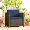 Rattan armchair with navy cushion and mixed brown woven frame, front view on patio.