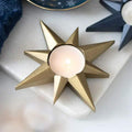 Gold star tealight candle holder with lit tealight in round cup center