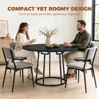 Round black dining table with conical metal base and compact round top
