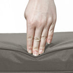 Dark grey cushion with locking zipper, showing hand fastening the cover