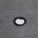Round umbrella hole opening in dark square tabletop