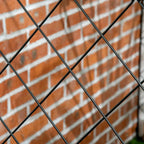 Black metal diamond wire lattice fence panel with crisscross pattern and arched top