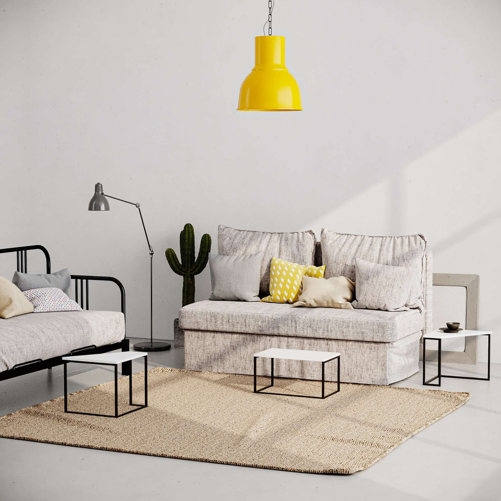 Modern coffee table with white top and black metal frame in a living room setup