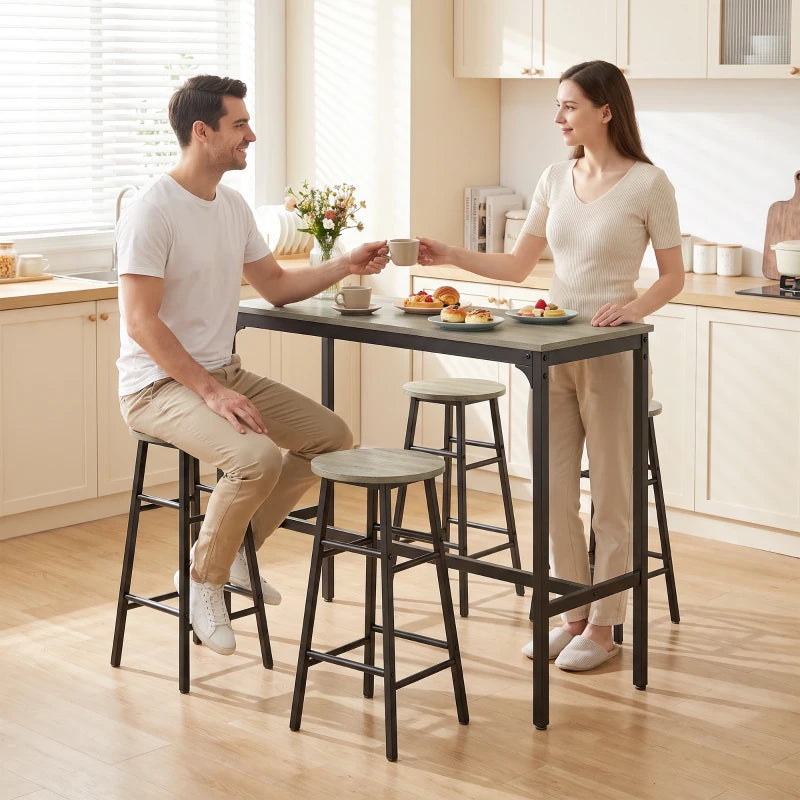 Grey bar table with four stools, black frames, seating setup in a bright kitchen