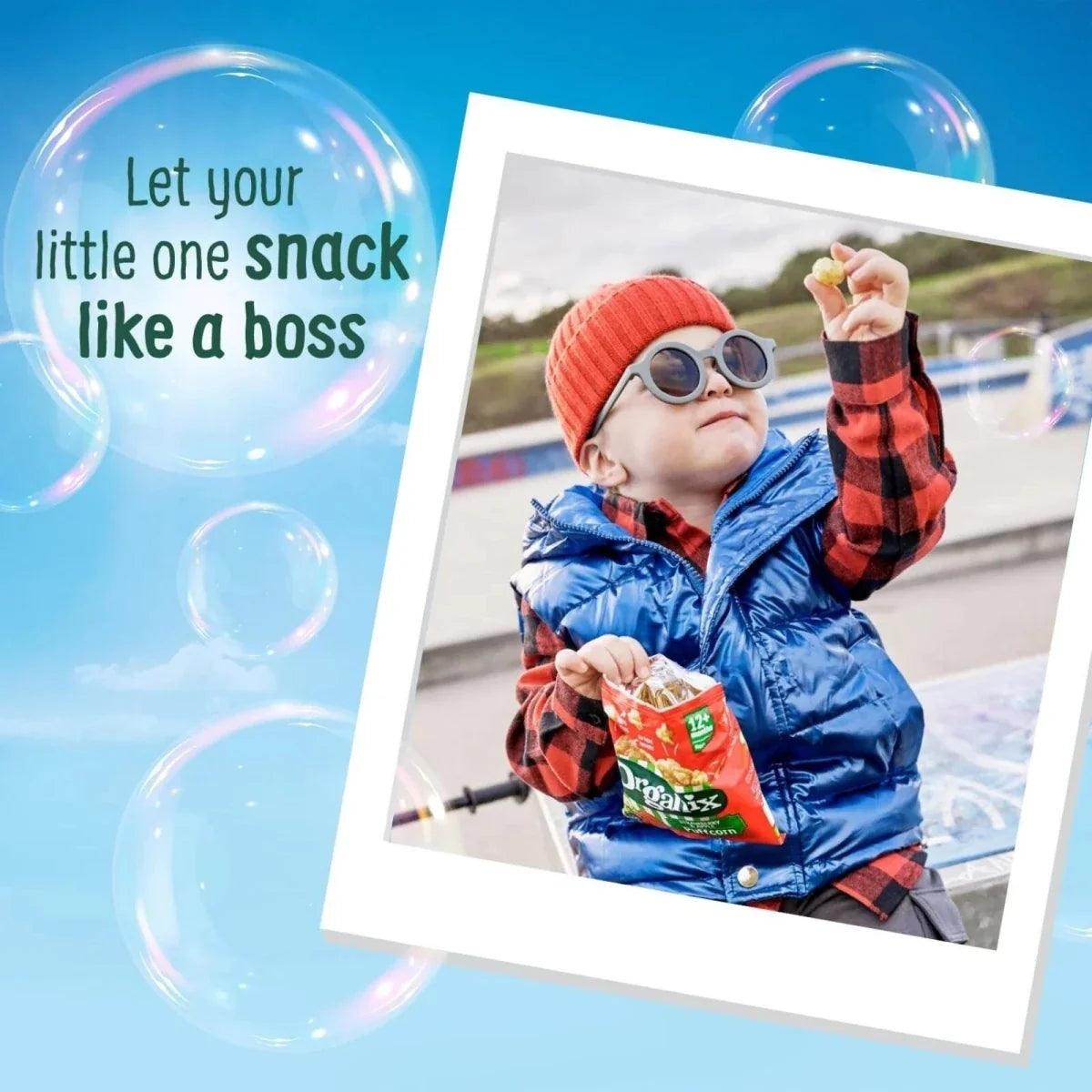 Child holding an Organix Puffcorn strawberry & apple snack bag