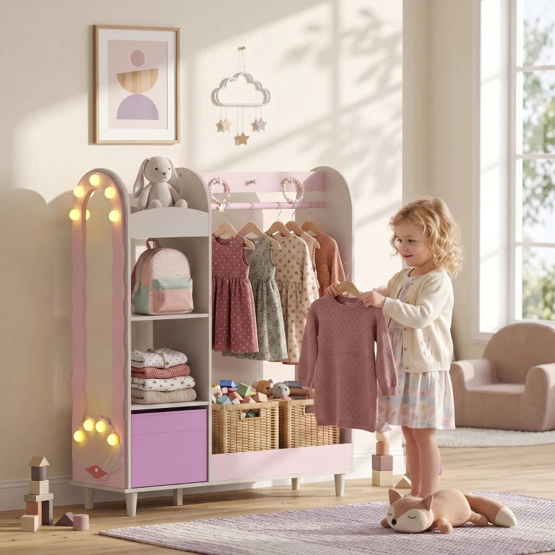 Pink kids clothing wardrobe with mirror and glowing lights, open shelves with hanging clothes.