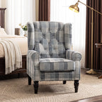 Wingback accent chair with blue-gray plaid upholstery, rolled arms, and dark legs
