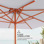 Close-up of grey square parasol canopy with orange ribs and wooden central pole.