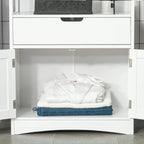 White cabinet with open drawer showing neatly folded towels and bath accessories