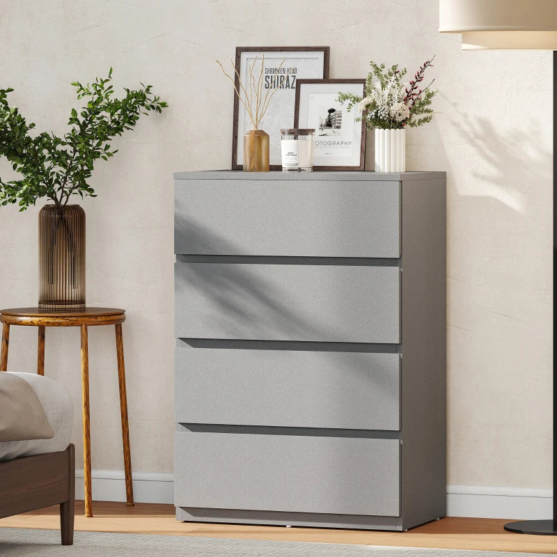 Grey four-drawer dresser standing against wall with smooth drawer fronts.