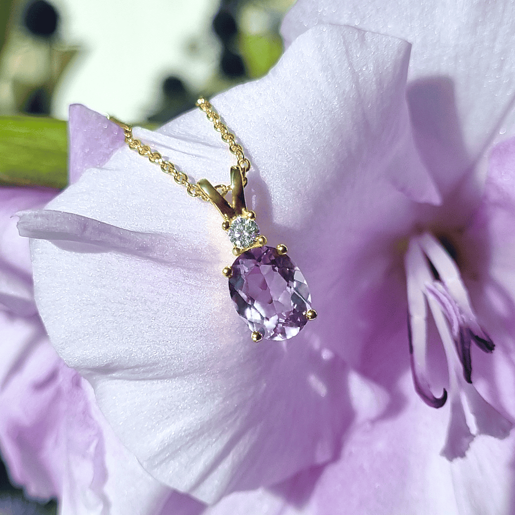 Lavender amethyst pendant on gold chain with sparkle accents near the bail