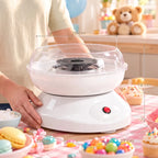 White cotton candy machine with clear bowl, black heating plate, and red power button