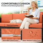 Orange outdoor rattan sofa with thick padded cushions and water-resistant cover look