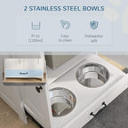 Two stainless steel raised dog bowls on a white feeding station with side hooks