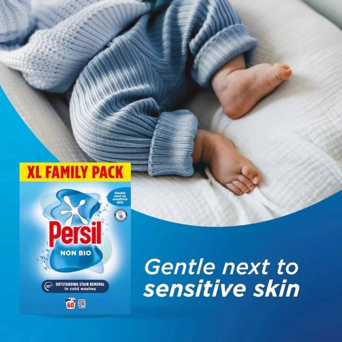 Persil Non Bio washing powder XL family pack beside folded blue baby knit clothes