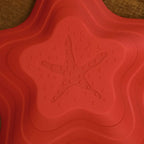 Red starfish stepping stone close-up with raised textured grip pattern.