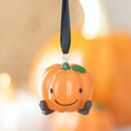 Smiling orange pumpkin ornament with green leaf, black strap, and dangling hook