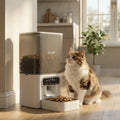 White programmable cat feeder with dispensing tray and orange tabby cat