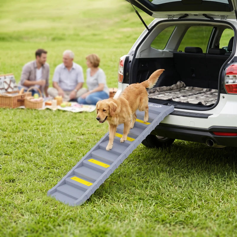 Grey 10-step dog ramp with yellow anti-slip strips beside an SUV