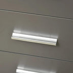 Close-up of a grey drawer front with a brushed silver handle.