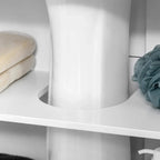 White under sink cabinet interior shelf with towels and a round cutout