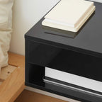High-gloss black floating bedside table detail with open shelf and drawer space
