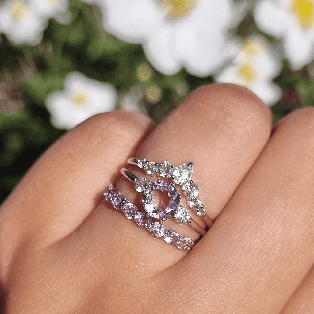 Sterling silver ring set with lavender amethyst center and diamond halo on finger