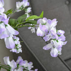 Close-up of artificial wisteria flowers with lilac-purple and white petals