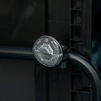 Front reflector light on black bike trailer frame with clear lens