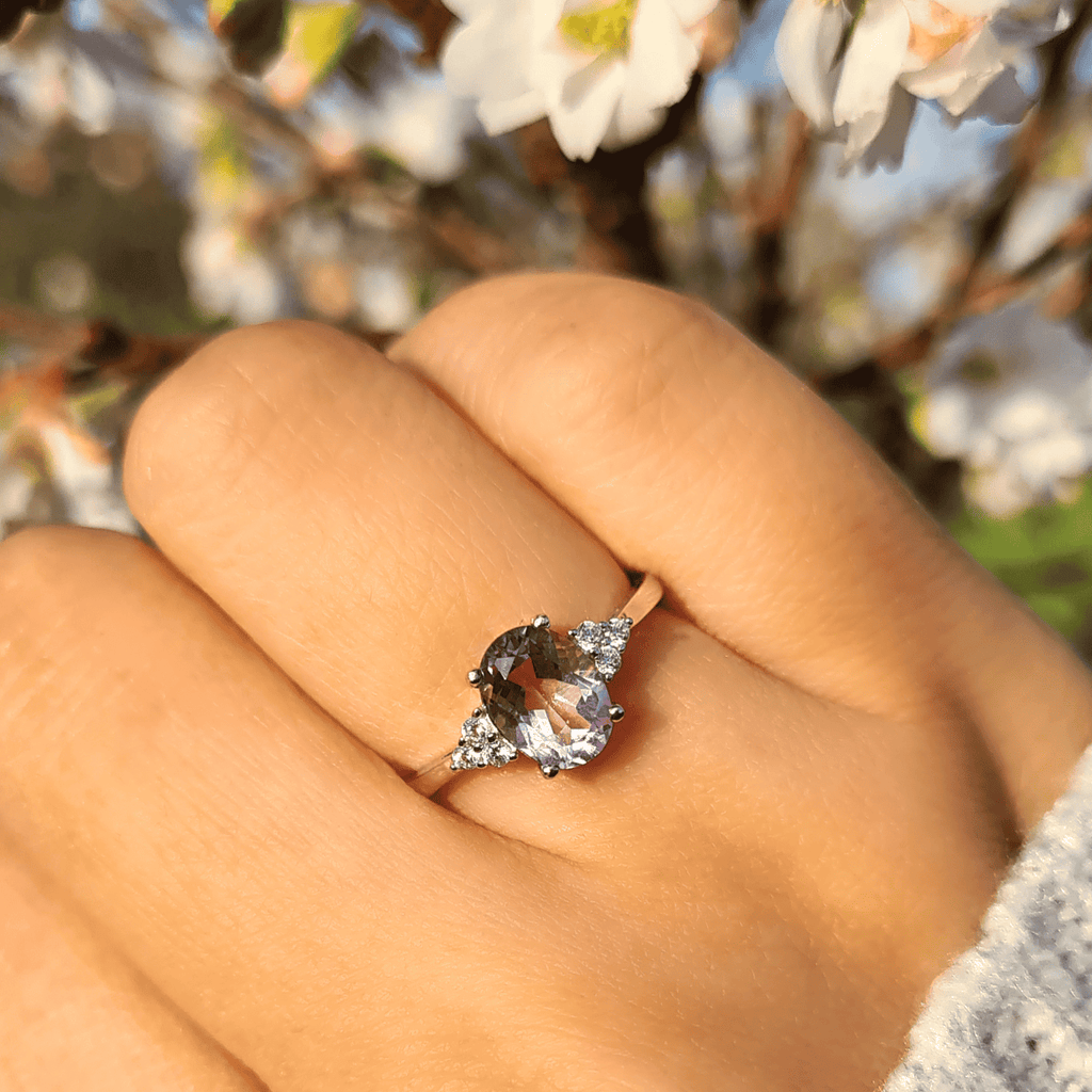 Sterling silver ring with round dark gemstone and small prong-set diamond accents