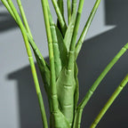 Close-up of green artificial monstera stems and trunk base