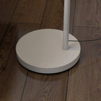 Round white base of floor lamp with power cord on wood flooring