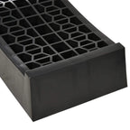 Close-up of black plastic ramp end with raised lip and grid anti-slip surface