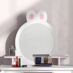 White bunny-shaped mirror vanity with pink accents and makeup items on tabletop