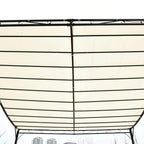 Underside view of cream gazebo canopy with black crossbars and center support pole
