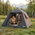 Dark grey camping tent with red trim, open front door and two people inside
