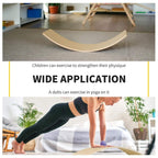 Natural wood wobble board with two hanging ropes on an exercise mat