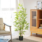 Artificial bamboo plant with green leaves in a black pot in a bright living space