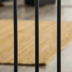 Black pet safety gate vertical bars close-up with base frame feet visible