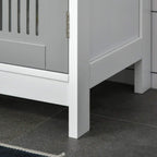 Grey under-sink cabinet corner with slatted door and white raised legs.