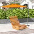 Outdoor light brown wooden rocking chair with slatted back and seat under an umbrella