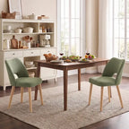 Two green upholstered dining chairs with curved backs, foam seats, and light wood legs