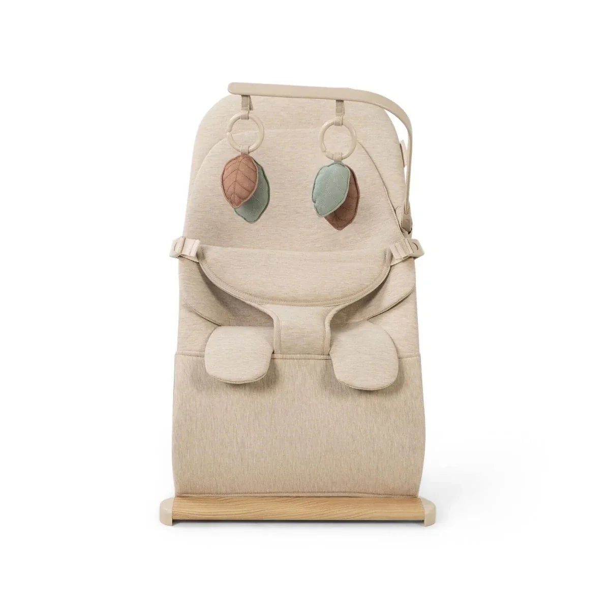 Oatmeal baby bouncer with front harness pad, two hanging leaf toys, and wooden base