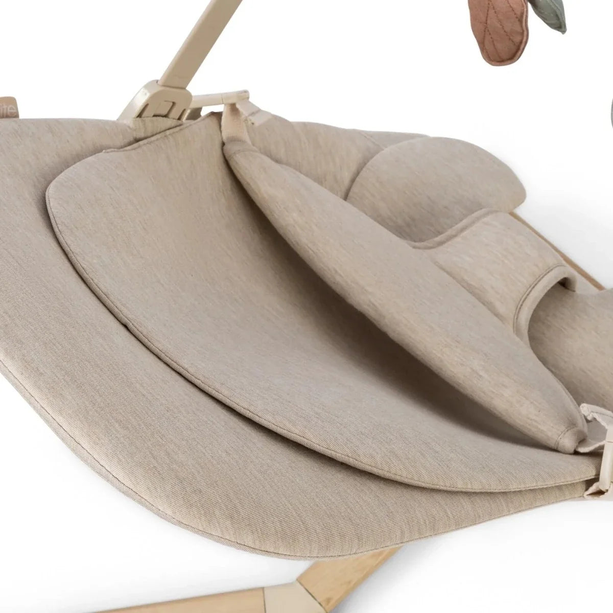 Oatmeal baby bouncer close-up of seat liner, three-point harness straps, and leg support