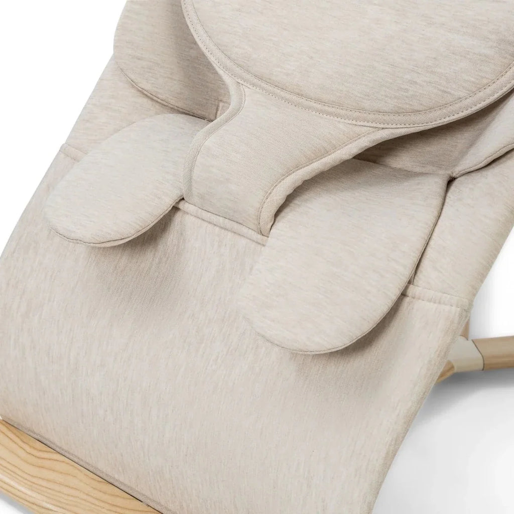 Oatmeal bouncer seat with arched headrest and safety strap
