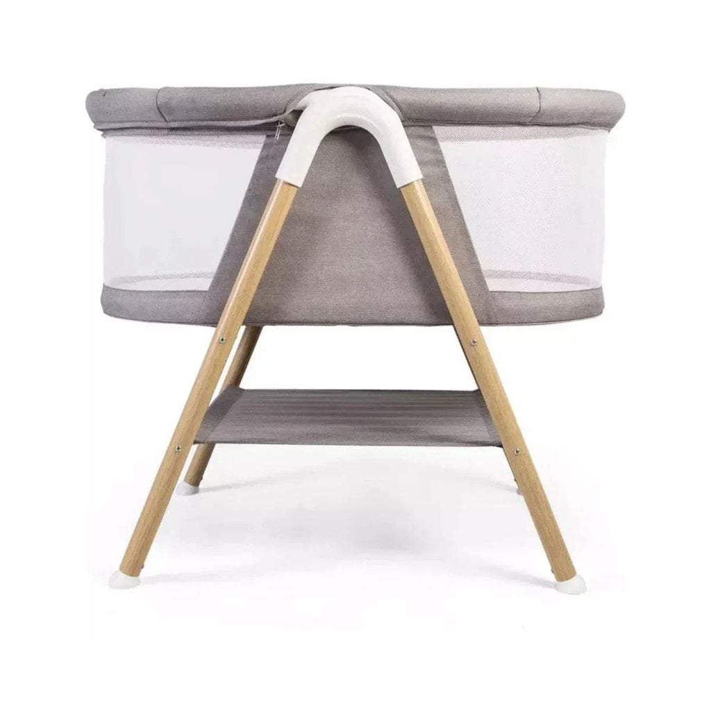 Grey snooze crib bassinet with curved side handle, wooden legs, open lower shelf.