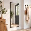 Black-framed full-length rectangular mirror mounted on a hallway wall