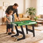 Green mini pool table set with balls and cues, shown in a living room