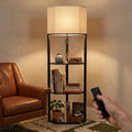 Black floor lamp with lit fabric shade, three shelves, and remote control