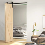 Black sliding barn door hardware track mounted on top of light wood door leaf